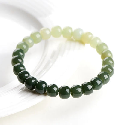 Natural Hetian jade bracelet showing gradient clear water colour on polished beads with either 6x7mm or 7x8mm dimensions