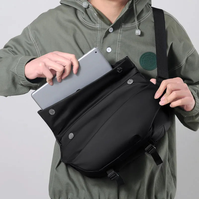 Grey crossbody bag with single shoulder strap showing zipper opening and internal organisation pockets