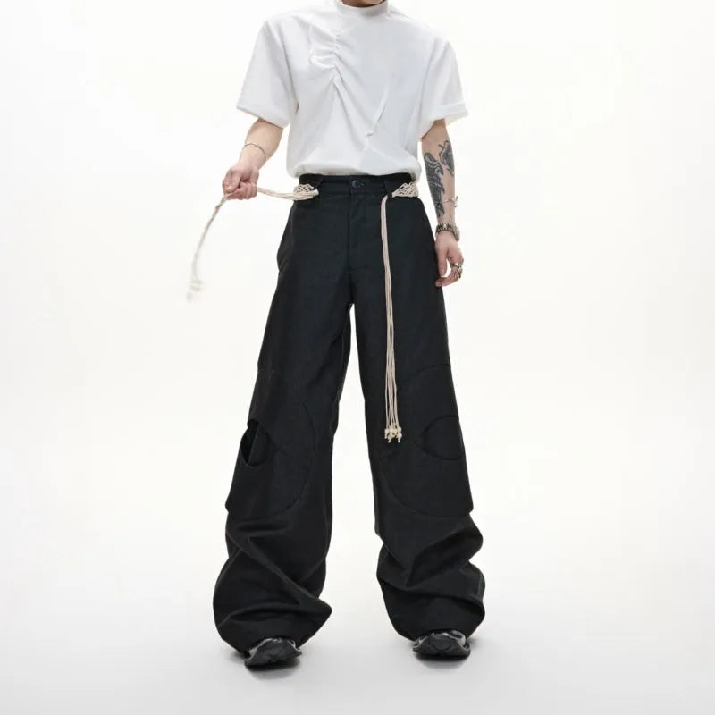Men's dark blue straight-leg cotton jeans with 3D cutting, belt stitching, and decorative tassel on a hanger