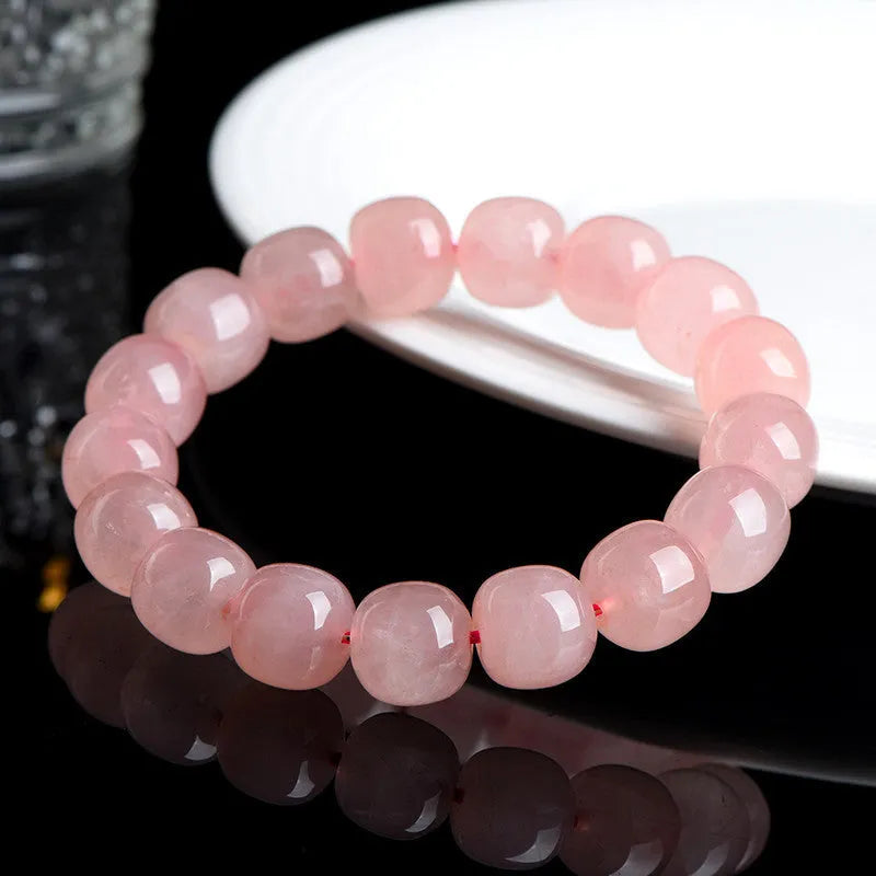 Natural crystal barrel shaped bead bracelet with 19 pink 8-10mm polished crystal beads in geometric pattern