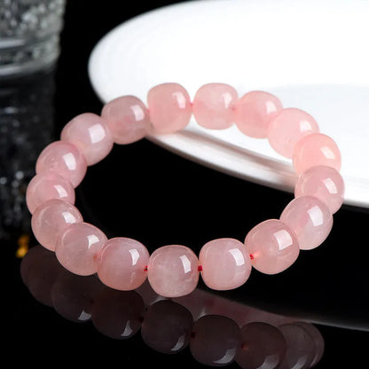 Natural crystal barrel shaped bead bracelet with 19 pink 8-10mm polished crystal beads in geometric pattern