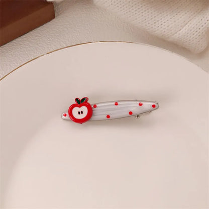 Red plastic hair clip with a 3D love heart and dots on a willow leaf-shaped base.