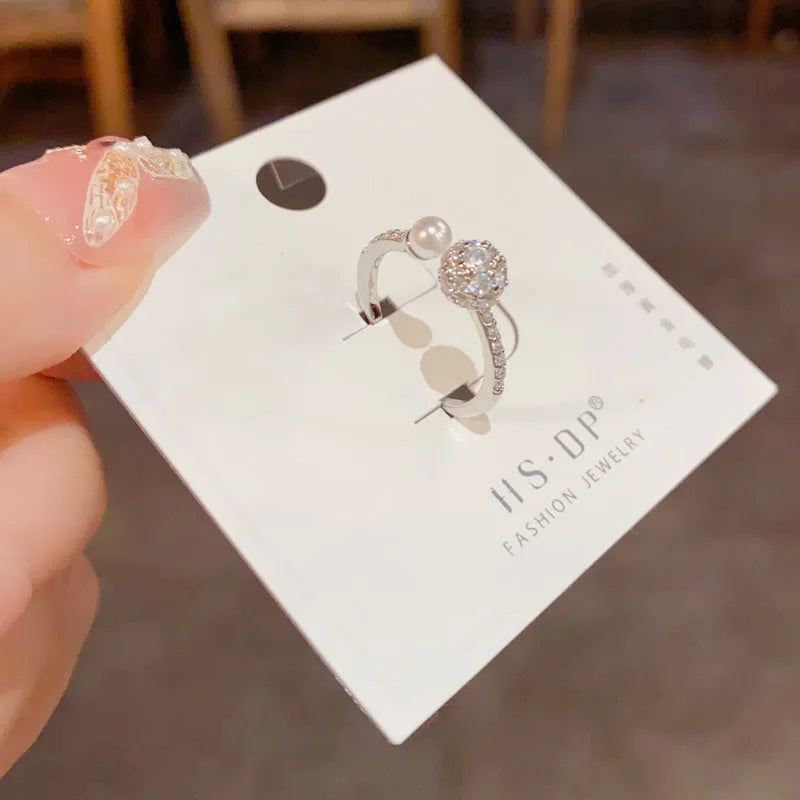Open-end pearl ring with round zircon stones on geometric copper band with gold plating