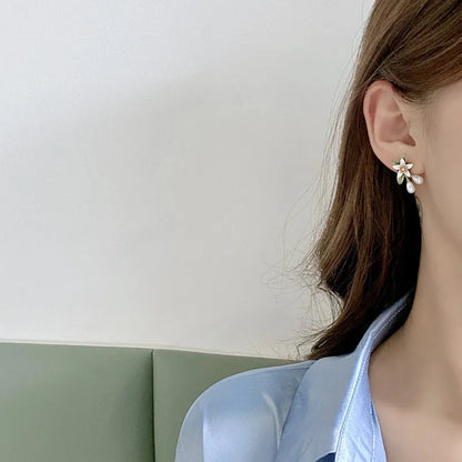 A pair of alloy flower ear studs and a pair of matching flower ear clips with a sterling silver needle detail.