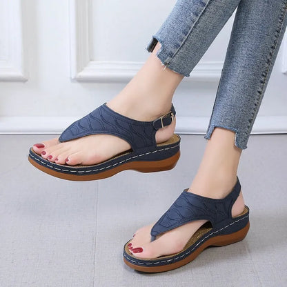 Women's wedge heel flip flop sandals in black with adjustable back strap on a light background