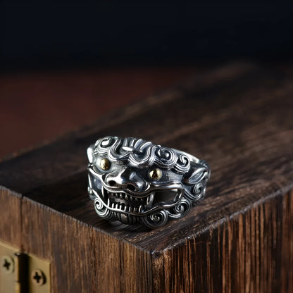 Silver open-style ring with a detailed raised jibeast animal pattern on a model's finger.