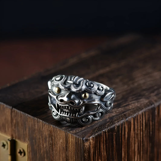 Silver open-style ring with a detailed raised jibeast animal pattern on a model's finger.