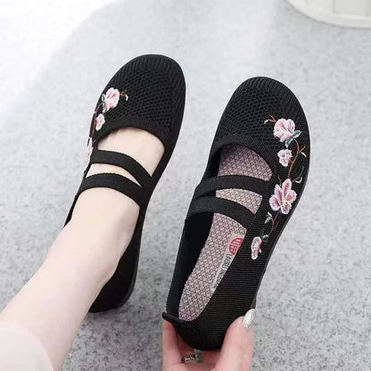 A pair of slip-on flat shoes with an elastic upper and rubber sole, shown in an embroidered colour option.