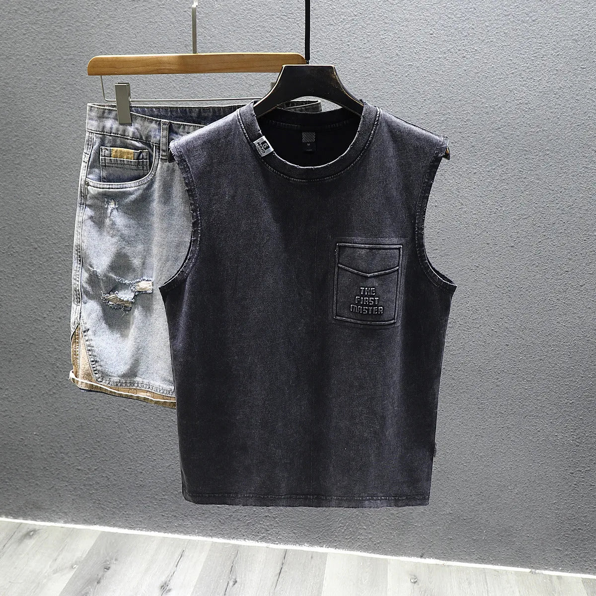 Men's solid colour loose fit cotton sleeveless t-shirt on a hanger, shown in white and black.