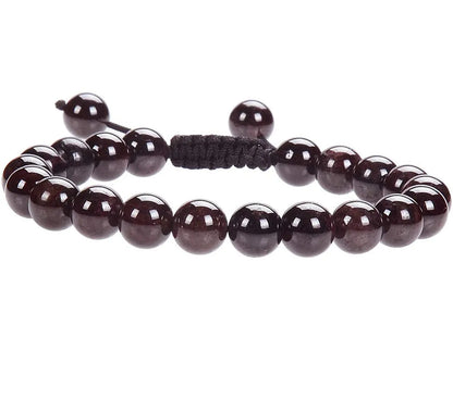 Close-up of a women's flat knot braided healing bracelet hand-woven with colourful gemstones.