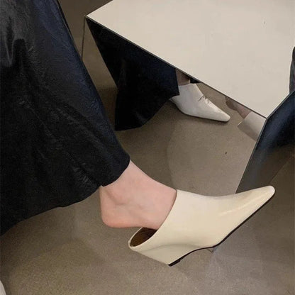 Women's black wind wedge closed toe half slippers on a plain background.