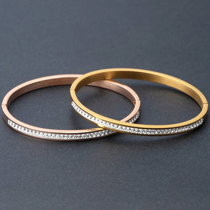 Elegant stainless steel bracelet with diamond accent, available in gold, rose gold, and steel finishes.