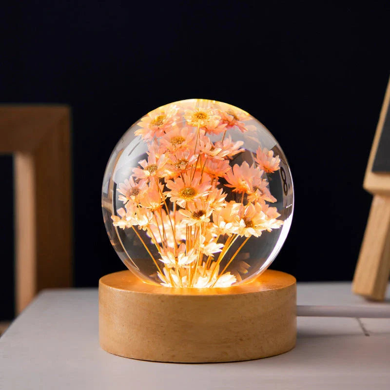 Enchanting 3D dandelion, yellow daisy, or red daisy flowers suspended in a clear crystal ball with a beech wood base, creating a mesmerizing desktop decor piece.