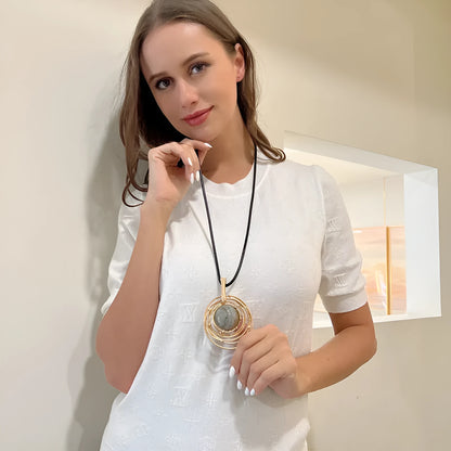 Gold geometric plaid pendant necklace on a textured snakeskin-style rope chain, laid out to show length.