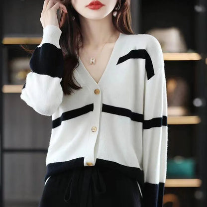 Women's black and white striped V-neck cardigan with buttons, showing a textured 3D knit pattern.