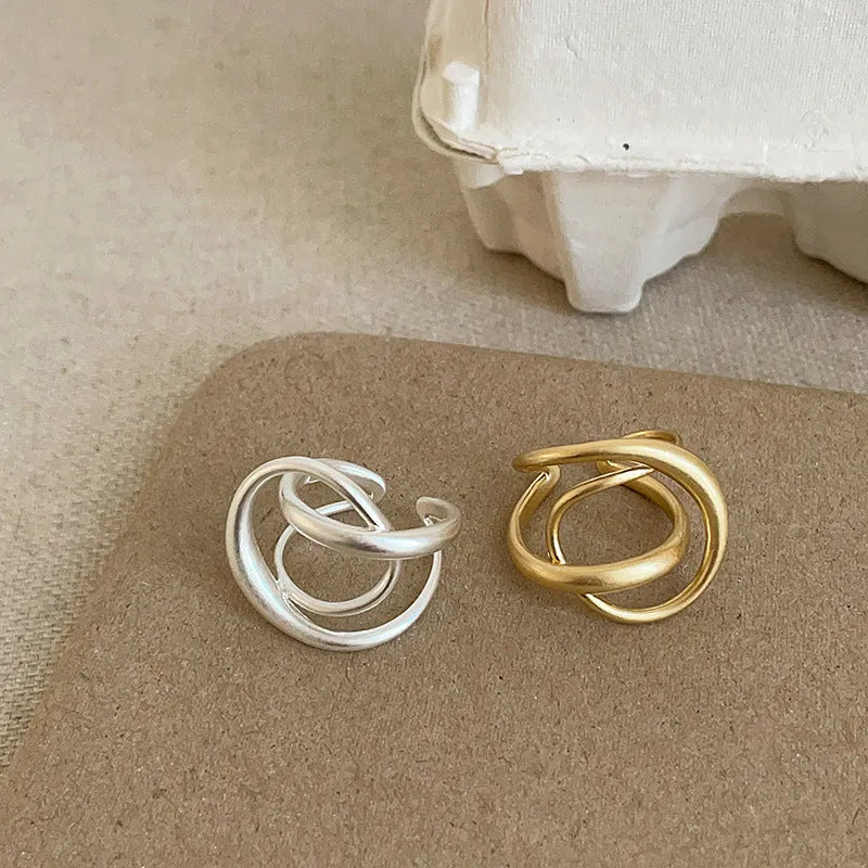 Three-dimensional interlaced matte metal open ring for women: a geometric design with electroplated real gold finish in gold or silver options, featuring an adjustable open band for versatile sizing.