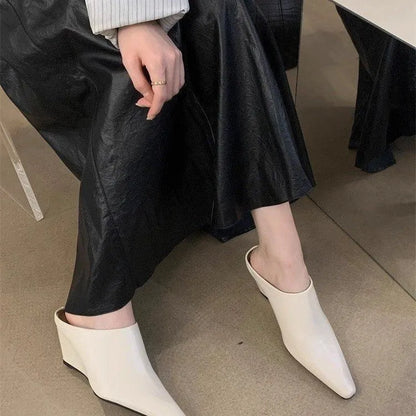 Women's black wind wedge closed toe half slippers on a plain background.