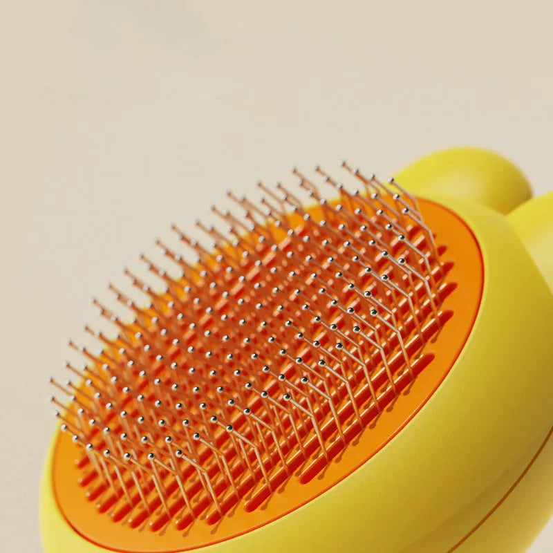 Green self-cleaning pet grooming brush with a release button and rubber-tipped metal pins on a non-slip handle.