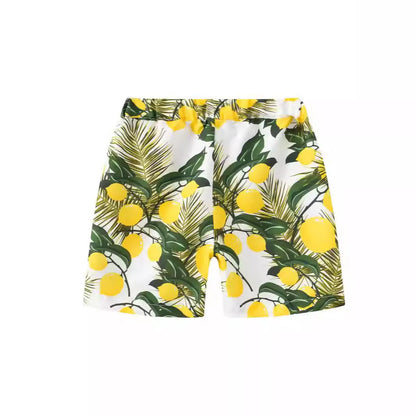 Colourful printed beach shorts with elastic waistband showing tropical patterns including coconut trees and pineapples