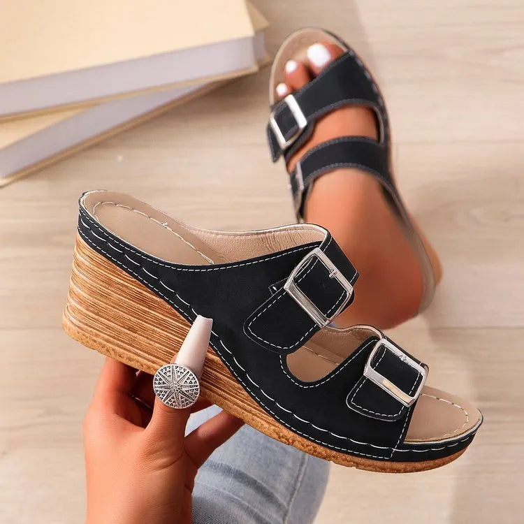Women's creamy-white wedge slippers with an outer belt buckle and a rubber sole.