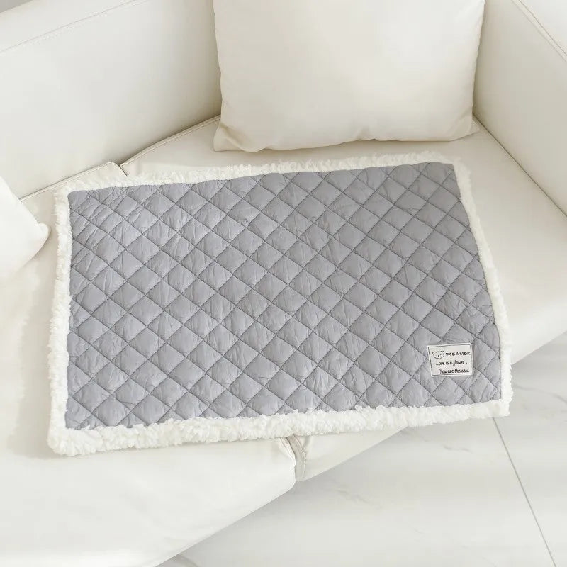 Quilted terry cloth pet blanket for cats in blue, grey, pink, or yellow colour on a pet bed.