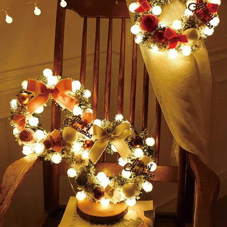Multicolor Christmas LED light wreath with red berries, pine cones, and holly leaves