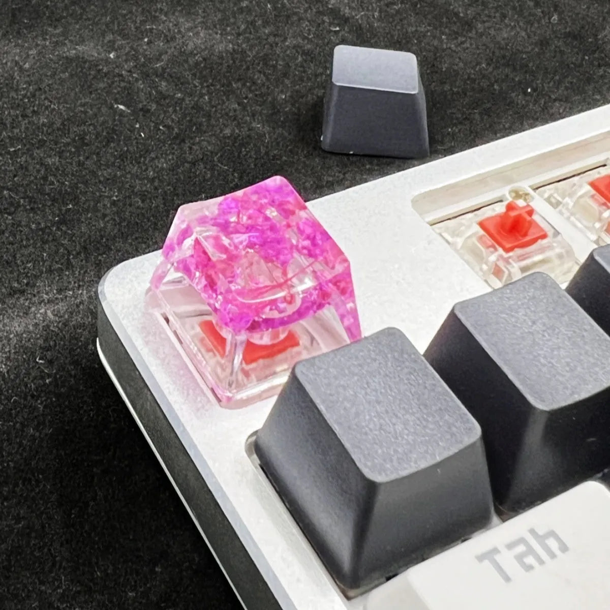 A transparent resin keycap with a starry sky design inside, shown in a green colour variant.
