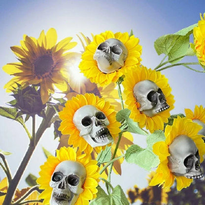 A group of skull-shaped sunflower ornaments arranged in a Halloween-themed outdoor display
