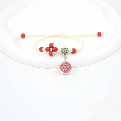Hand-woven glass bracelet with large 1.4 cm beads containing real dried flowers, shown in blue.