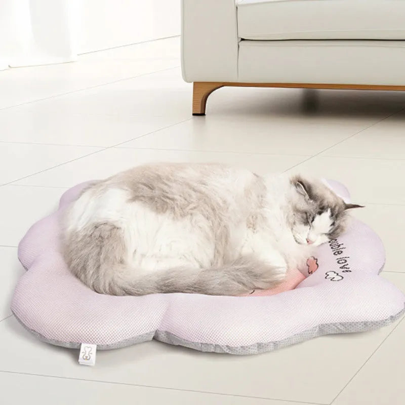 Green and pink pet cooling mats for dogs and cats in four different sizes on a wooden floor.