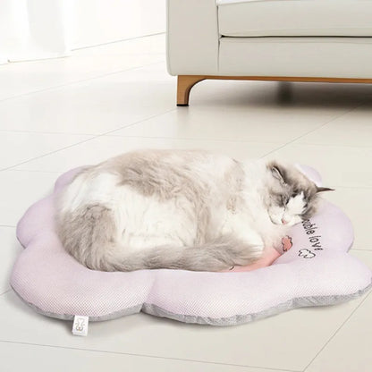 Green and pink pet cooling mats for dogs and cats in four different sizes on a wooden floor.