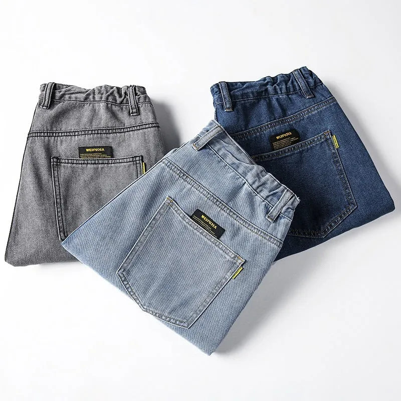 Men's dark blue loose straight fit cotton jeans with a zipper fly, shown on a hanger.