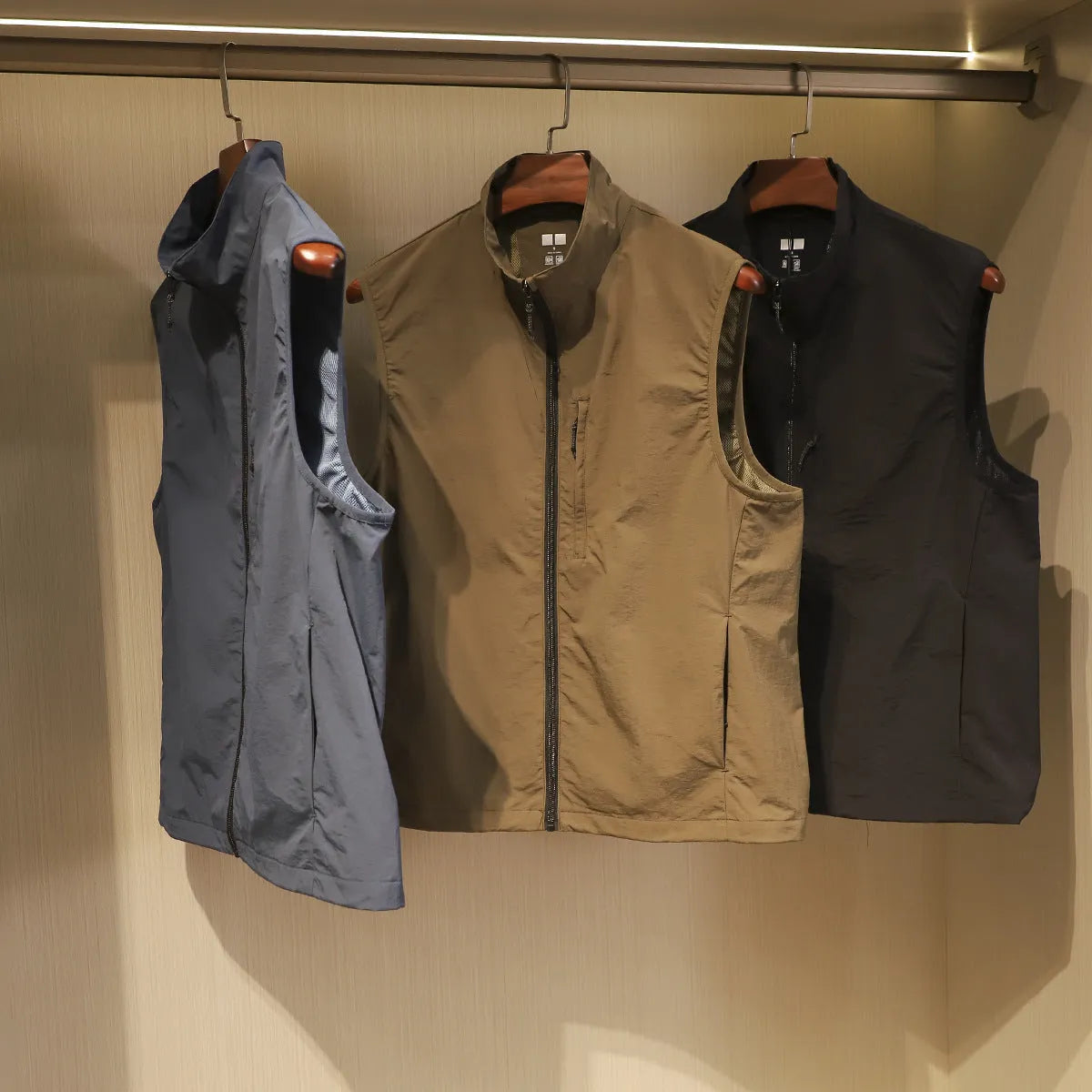 Men's navy blue quick-dry nylon vest cardigan with side pockets on a hanger