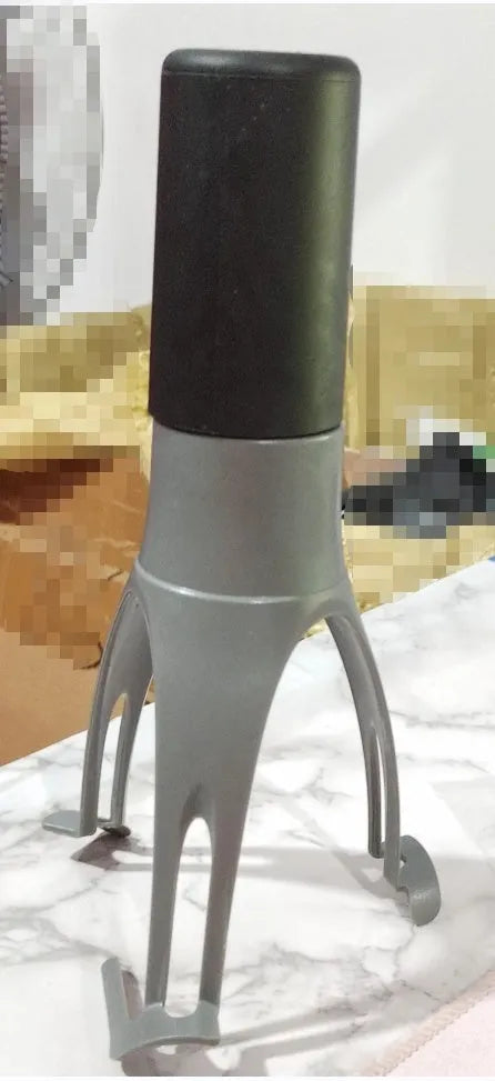 Uutensil Stirr automatic electric kitchen mixer device in green, shown next to a saucepan.
