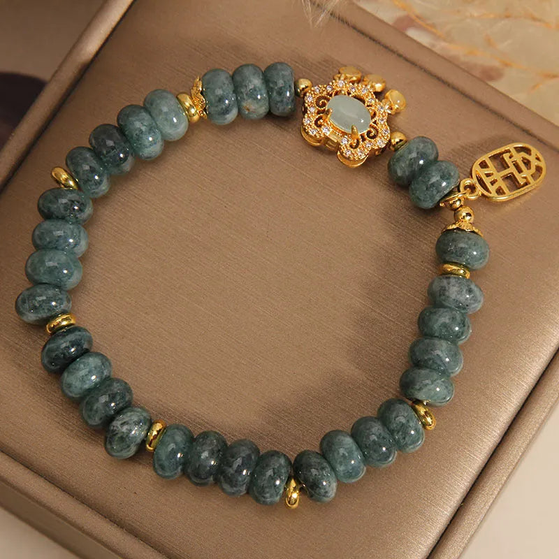 Close-up of a women's bracelet with green emerald jade abacus beads and a silver alloy safety lock clasp.