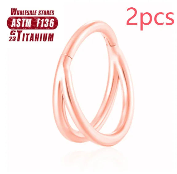 Pair of titanium alloy nose rings on a plain background showing silver, gold, black, and rose gold colour options.