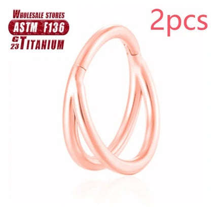 Pair of titanium alloy nose rings on a plain background showing silver, gold, black, and rose gold colour options.