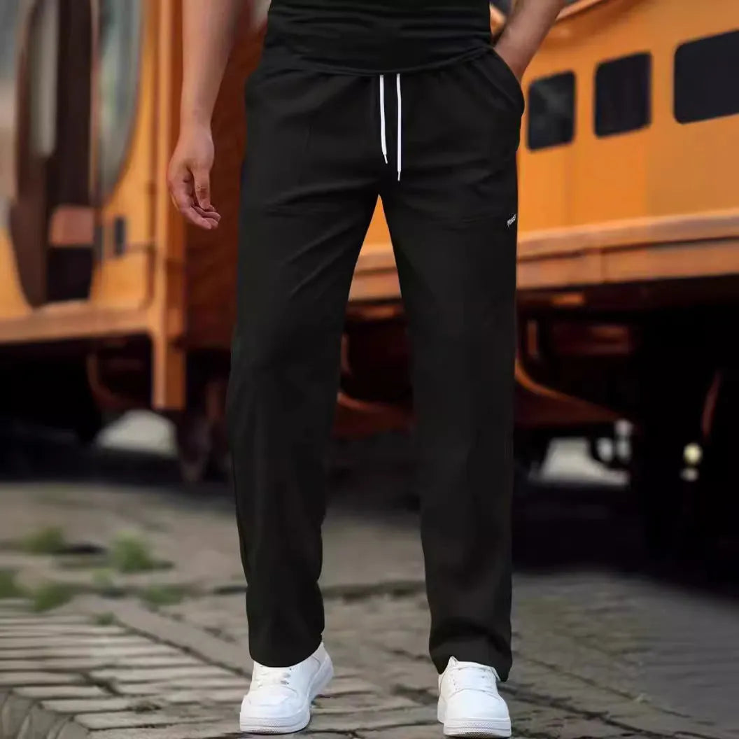 Men's polyester trousers for spring and autumn in light grey, shown in a casual setting