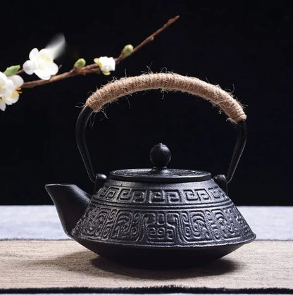 Japanese-style cast iron teapot with lid on a hob, shown in a bronze finish.