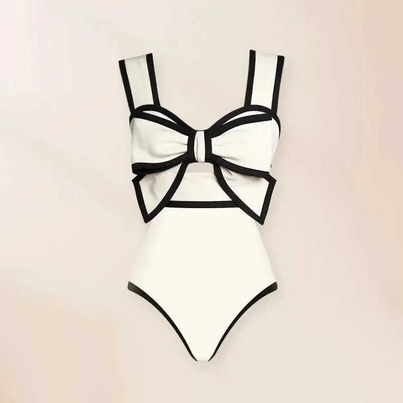 Women's black one-piece swimsuit with white skirt and bow detail for beach swimming