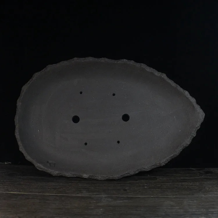 Handmade purple clay flower pot with unique shape showing natural ceramic texture