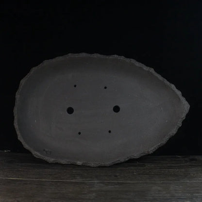 Handmade purple clay flower pot with unique shape showing natural ceramic texture
