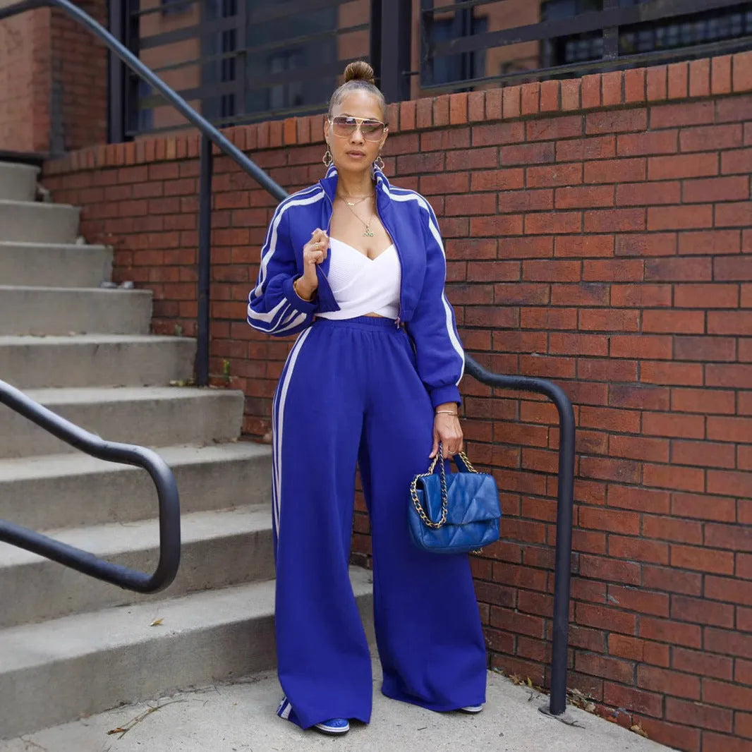 Grey striped streetwear two-piece suit set with zipper detailing on the top and trousers.