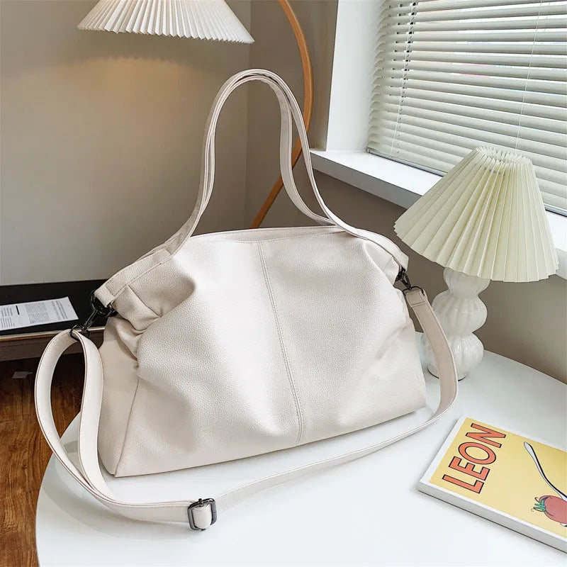 Large soft black PU messenger bag with long shoulder strap and front car suture detailing