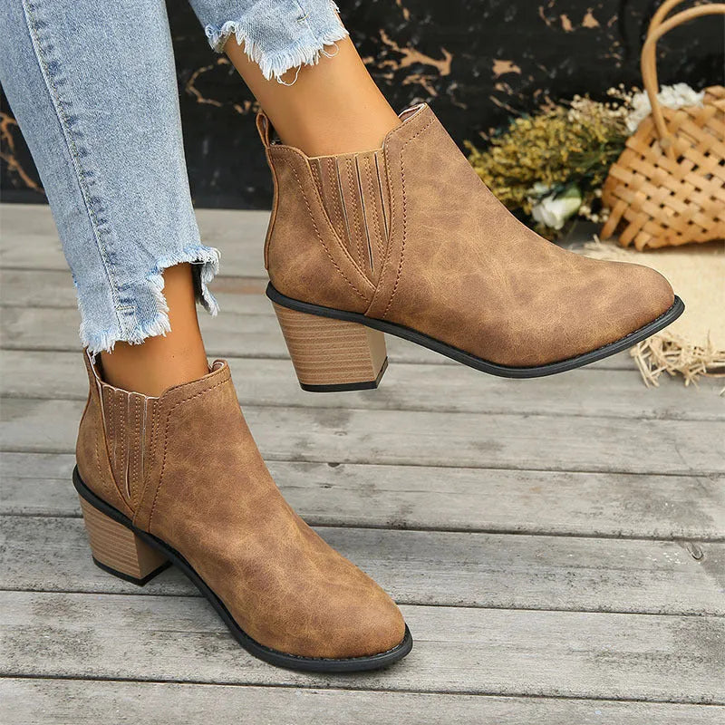 Black and brown women's ankle boots with a pointed toe and thick square low heel, slip-on design.