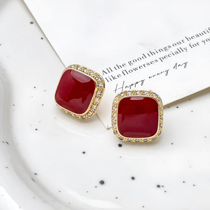 Red square alloy earrings with an inlaid geometric design, shown from the front.