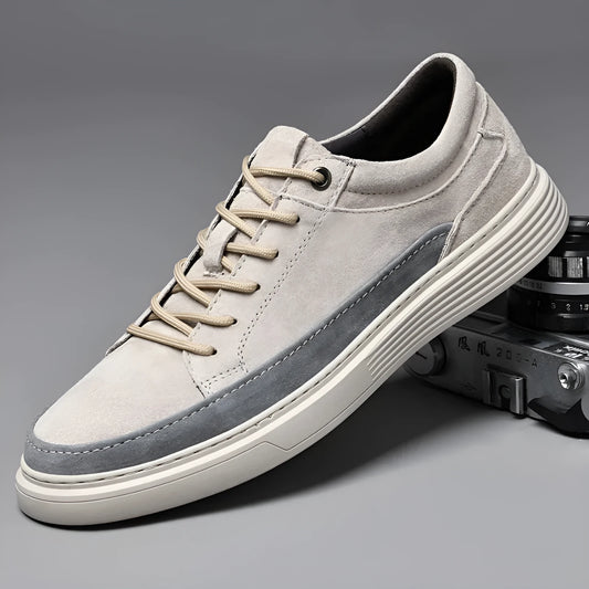 Men's grey low-top casual leather skate shoes with round toe and flat rubber sole on a wooden surface.
