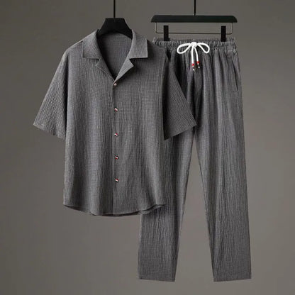 Man wearing a grey Chinese-style casual two-piece set with a short-sleeve knit top and full-length trousers.