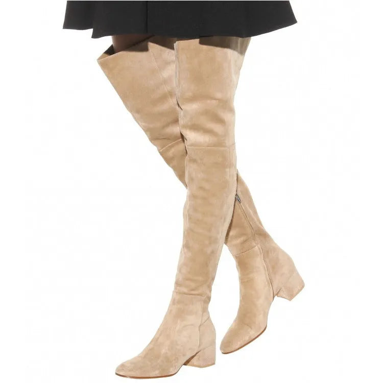 Women's grey suede over-the-knee flat boots with pointed toe and thick rubber sole on a neutral background