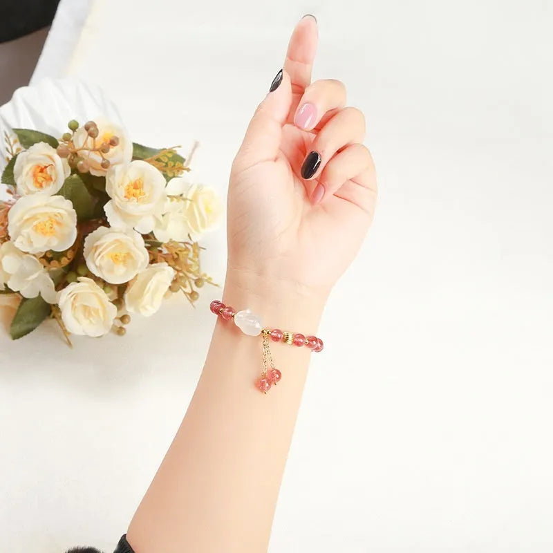 Women's strawberry quartz agate bracelet with 6mm round beads and white rabbit charm.